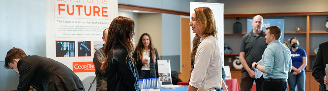 Photo of an employer and a student talking at a career event